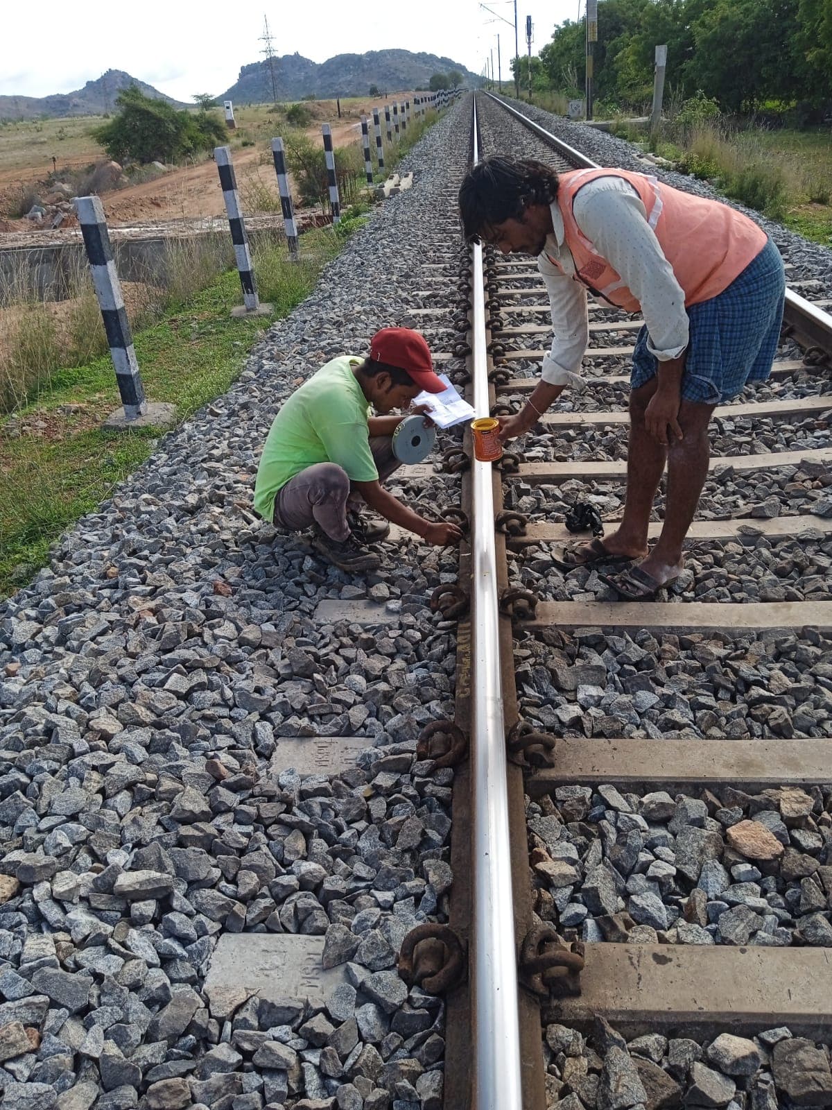 Track worker fastening rail on concrete sleepers